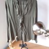 Blusa verde seco con volante medio al cuello.