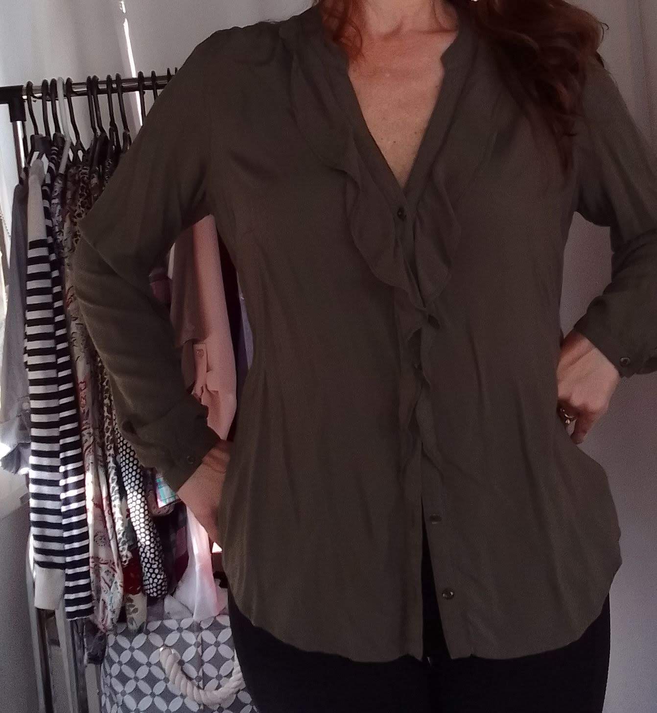 Blusa verde seco con volante medio al cuello.